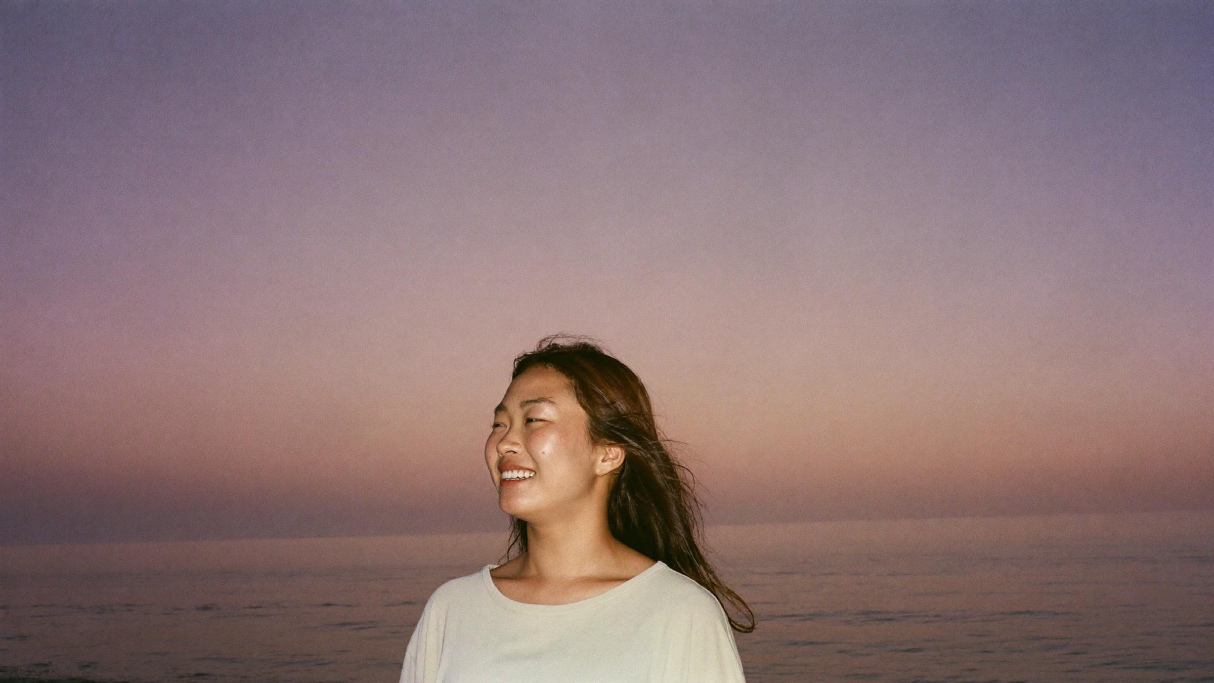 A woman by Manila Bay at dusk, smiling